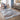 Living room with a patterned area rug, armchair, and decorative elements.