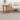 Two wooden side tables with a plant and small bowl next to a beige sofa on a textured rug.