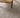 Close-up of a textured gray carpet with a wooden chair leg visible.