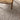 Close-up of a textured gray carpet with a wooden chair leg visible.
