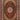 Decorative rug with intricate patterns in red and beige on a plain background