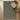 Green rug on a wooden floor with a chair and small table.
