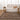 Living room with a patterned rug, beige sofa, and wooden side tables.
