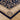 Close-up of a blue and beige patterned rug on a wooden floor