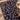 Decorative blue and gold patterned rug with a wooden table corner.