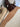 Brown blanket draped over a chair on a patterned rug with a wooden side table and decorative items.