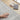 Gray textured rug on a wooden floor with headphones and a book.