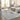 Living room with a gray rug, beige sofa, and cityscape artwork.