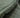 Close-up of a textured green fabric with frayed edge