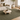 Living room with a green rug, beige sofa, wooden chair, and coffee table.