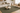 Living room with a green rug, beige sofa, wooden chair, and coffee table.