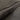 Close-up of a textured dark brown rug with frayed edges