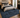A large traditional-style area rug in deep blue and navy tones with an ornate distressed pattern, shown in a styled bedroom setting