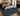 A large traditional-style area rug in deep blue and navy tones with an ornate distressed pattern, shown in a styled bedroom setting
