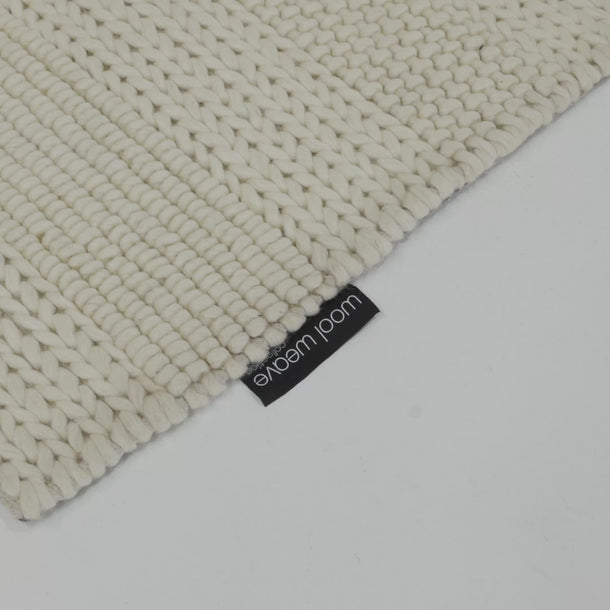Ivory wool rug in natural light showing thick textured weave and natural wool detail