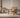 Wooden chair with wicker backrest next to a yellow bicycle in a room with a neutral color scheme.